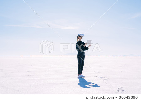 Young woman with VR glasses and tablet at Salt Flats Young woman with VR glasses and tablet at Salt Flats 88649886