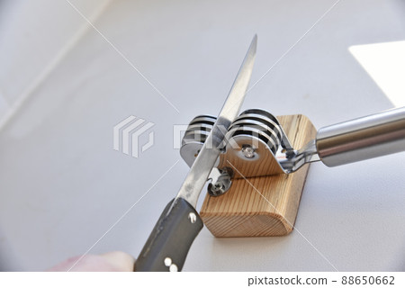 Sharpening an iron knife with a sharpener Sharpening an iron knife with a sharpener 88650662
