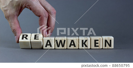 Reawaken symbol. Businessman turns cubes and changes the word 'awaken' to 'reawaken'. Beautiful grey background, copy space. Business and reawaken or awaken concept. 88650795