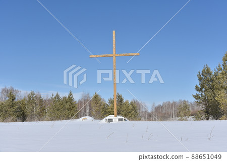 Christian cross in the field in winter in the forest Christian cross in the field in winter in the forest 88651049