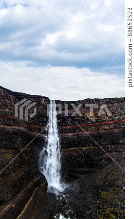 Hengifoss waterfall with deep red layers under cloudy sky 88651523