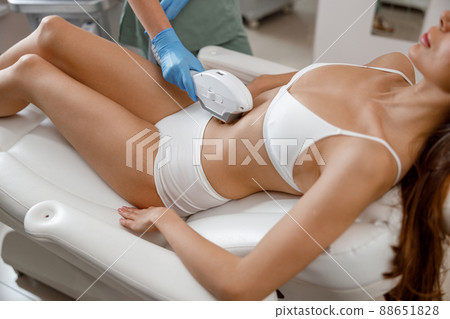 Woman with smooth skin getting photo epilation with ipl machine in beauty salon 88651828