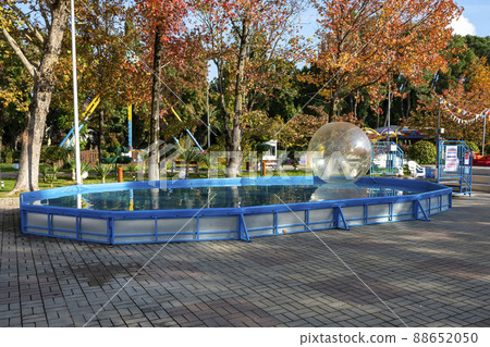 A small pool with a transparent ball for children in the autumn park. 88652050