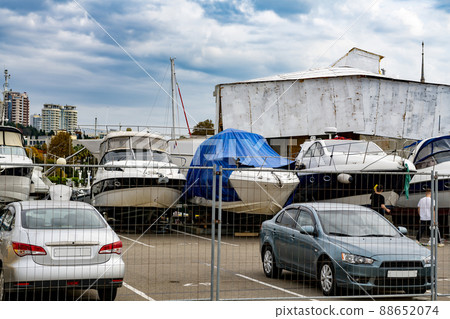 Parking for cars, yachts and boats against a cloudy sky. Parking for cars, yachts and boats against a cloudy sky. 88652074