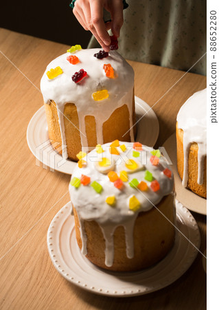 Girl decorates Easter cakes with jelly candies Girl decorates Easter cakes with jelly candies 88652280