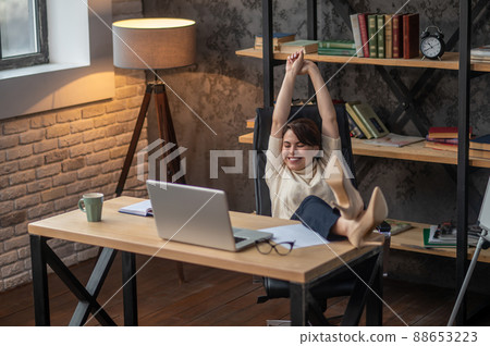 A young woman relaxing in the office after work A young woman relaxing in the office after work 88653223