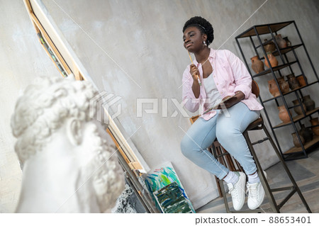 Contented african artist in pink clothes looking inspired Contented african artist in pink clothes looking inspired 88653401