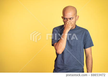 angry asian bald man covering nose with hands 88653472
