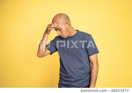 bald man wearing t-shirt thinking hard holding head bald man wearing t-shirt thinking hard holding head 88653477