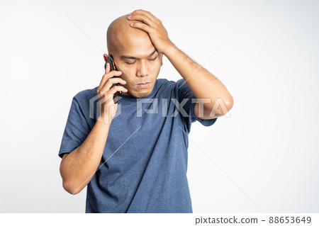 sad asian bald man scratching head while listening to phone sad asian bald man scratching head while listening to phone 88653649