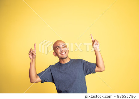 excited bald man with two fingers pointing up 88653780