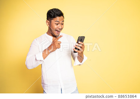 excited asian young man surprised when looking at the screen excited asian young man surprised when looking at the screen 88653864