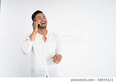young asian man laughing while making phone call 88654221