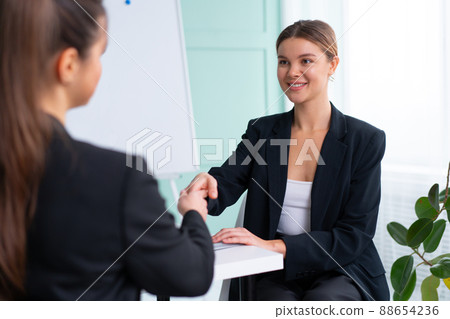 Job interview. Business, career and placement concept. Young blonde woman holding resume, while sitting in front of candidate during corporate meeting or job interview 88654236