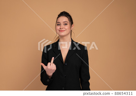 Business woman showing abuse gesture. Irritated smiling female in business suit showing middle finger, impolite rude gesture of disrespect, expressing hate and aggression in conflict Business woman showing abuse gesture. Irritated smiling female in business suit showing middle finger, impolite rude gesture of disrespect, expressing hate and aggression in conflict 88654311
