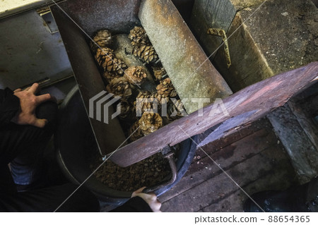 A man turns homemade device for extracting cedar A man turns homemade device for extracting cedar 88654365