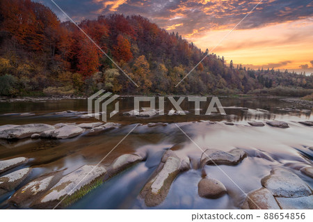 View of the waterfall in autumn. Waterfall in autumn colors. Mountain river in the autumn landscape. Ukraine, river Stryj. 88654856