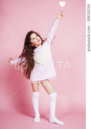 little cute girl with candy on pink background posing emotional, lifestyle people concept 88658326