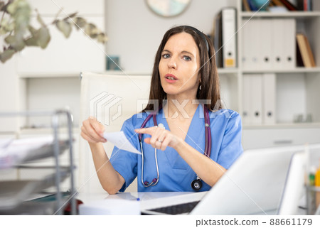 Portrait of female doctor with treatment sheet Portrait of female doctor with treatment sheet 88661179