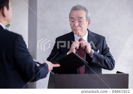 Senior man having a meeting with his subordinates before a business speech Senior man having a meeting with his subordinates before a business speech 88661922