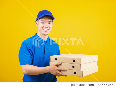 delivery service man standing he smile wearing blue t-shirt and cap uniform hold give food order pizza cardboard boxes delivery service man standing he smile wearing blue t-shirt and cap uniform hold give food order pizza cardboard boxes 88666467
