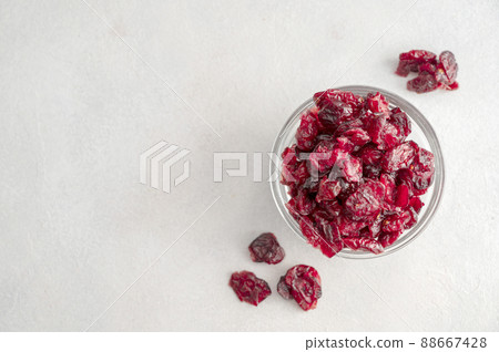 Dried cranberries in glass bowl over bright background, copy space 88667428