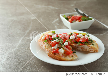 Plate with bruschetta snacks on gray textured table 88669834
