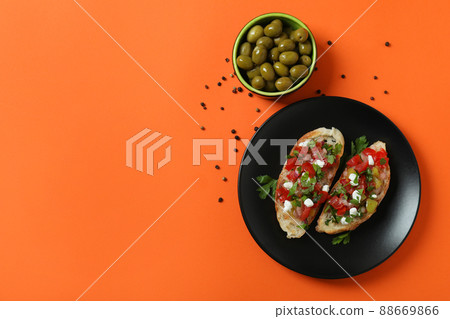 Delicious italian snacks bruschetta and ingredients on orange background Delicious italian snacks bruschetta and ingredients on orange background 88669866