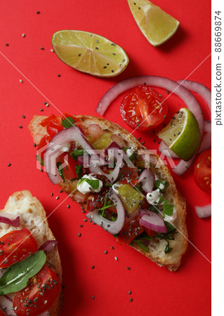 Delicious italian snack bruschetta on red background Delicious italian snack bruschetta on red background 88669874