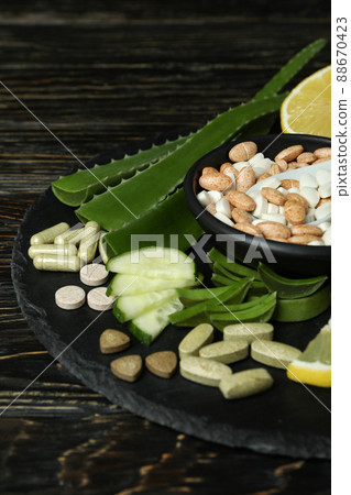 Concept of herb pills on rustic wooden table 88670423