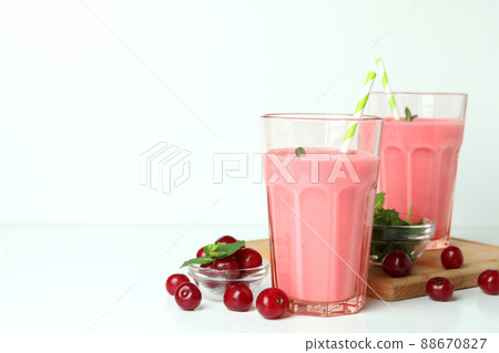 Glasses of cherry smoothie and ingredients on white table Glasses of cherry smoothie and ingredients on white table 88670827