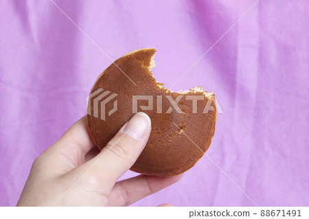 One pancake in hand on pink background One pancake in hand on pink background 88671491