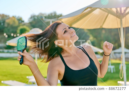 Mature beautiful woman in swimsuit relaxing in summer, combing her hair with comb 88672277