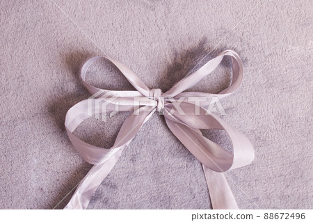 Bow made of gray ribbon on gray background 88672496