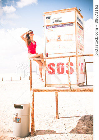 attractive woman in swimsuit in a lifeguard hut on the beach 88673162