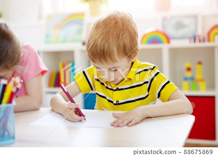 Schoolboy in the classroom sitting at the tables and writing a lesson. 88675869