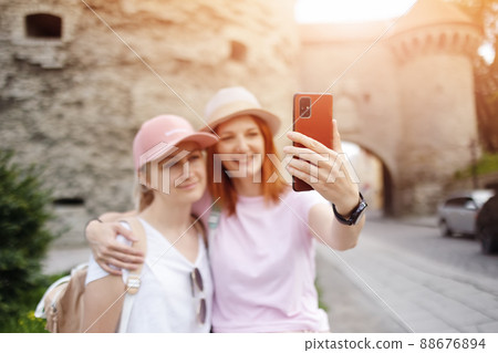 Two woman taking a selfie in old Tallinn, Estonia 88676894