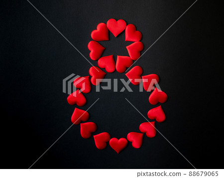 Digital symbol 8, laid out with red silk hearts on a black background. March 8. International Women's Day 88679065
