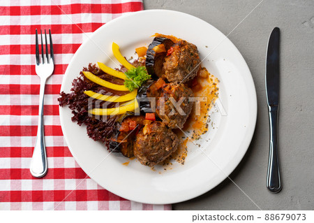 Cooked meat with fresh vegetable salad on a white plate Cooked meat with fresh vegetable salad on a white plate 88679073