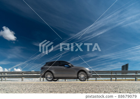White traces of condensation of water vapor from airplanes over the motorway White traces of condensation of water vapor from airplanes over the motorway 88679079
