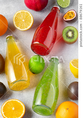 Various fruits and freshly squeezed fruits juice in bottle on gray background 88679161