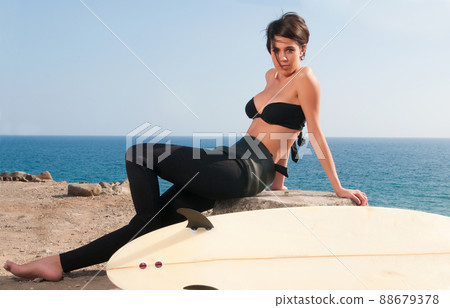 woman with surfboard under blue sky 88679378