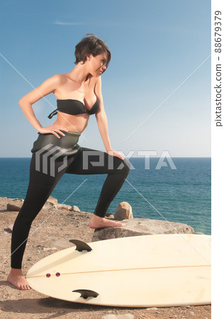woman with surfboard under blue sky 88679379