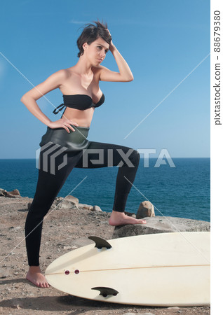 woman with surfboard under blue sky 88679380