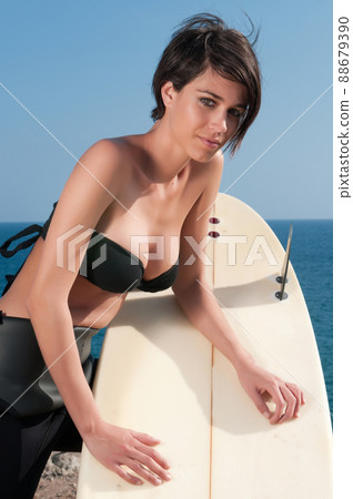 woman with surfboard under blue sky 88679390