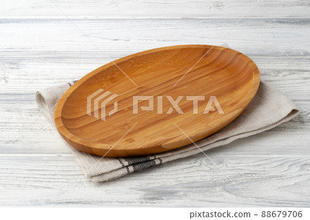 Wooden cutting board on cotton napkin on white wooden table 88679706