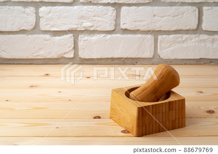 Wooden mortar with pestle on wooden background Wooden mortar with pestle on wooden background 88679769