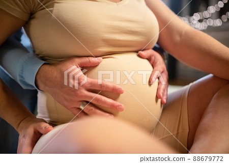Loving husband hugging pregnant wifes belly Loving husband hugging pregnant wifes belly 88679772