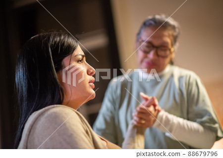 Side view of pregnant woman and blurry midwife at home Side view of pregnant woman and blurry midwife at home 88679796