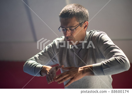 Middle-aged man with closed eyes gesturing hands Middle-aged man with closed eyes gesturing hands 88680174